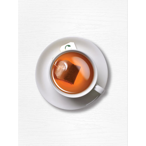 View 7 A turmeric tea bag steeps in a white cup on a white saucer.