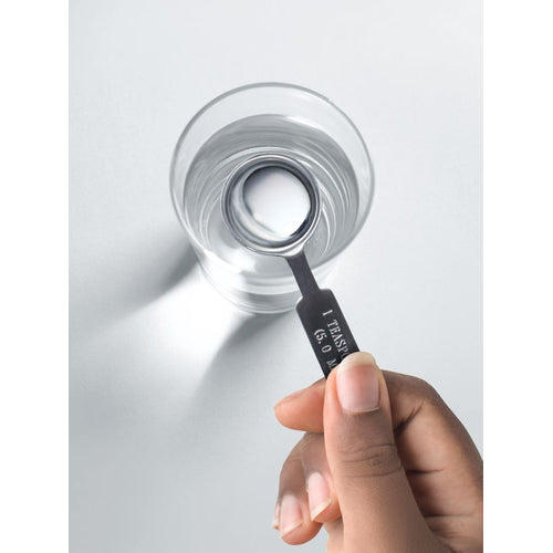 View 7 A hand holding a '1 TEASPOON (5.0 ML)' measuring spoon dips into a glass of clear liquid.