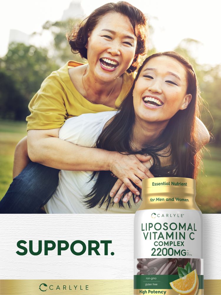 Two Asian women laughing and enjoying a piggyback ride, holding a Carlyle Liposomal Vitamin C bottle.
