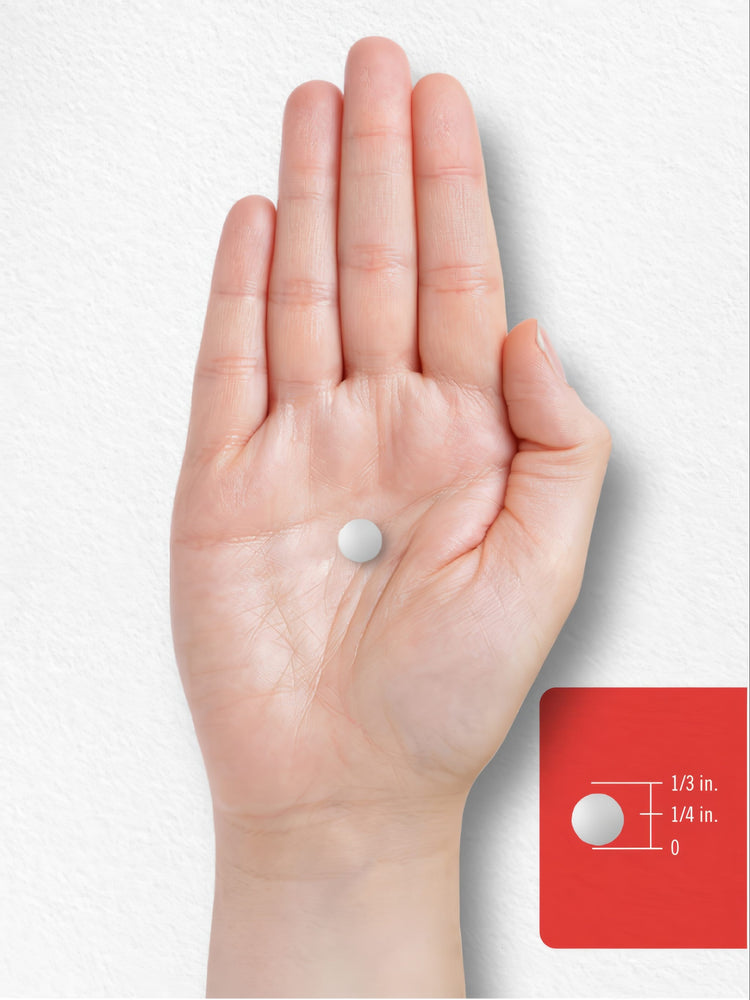 A hand holds a single round white tablet, approximately 1/4 inch in diameter.