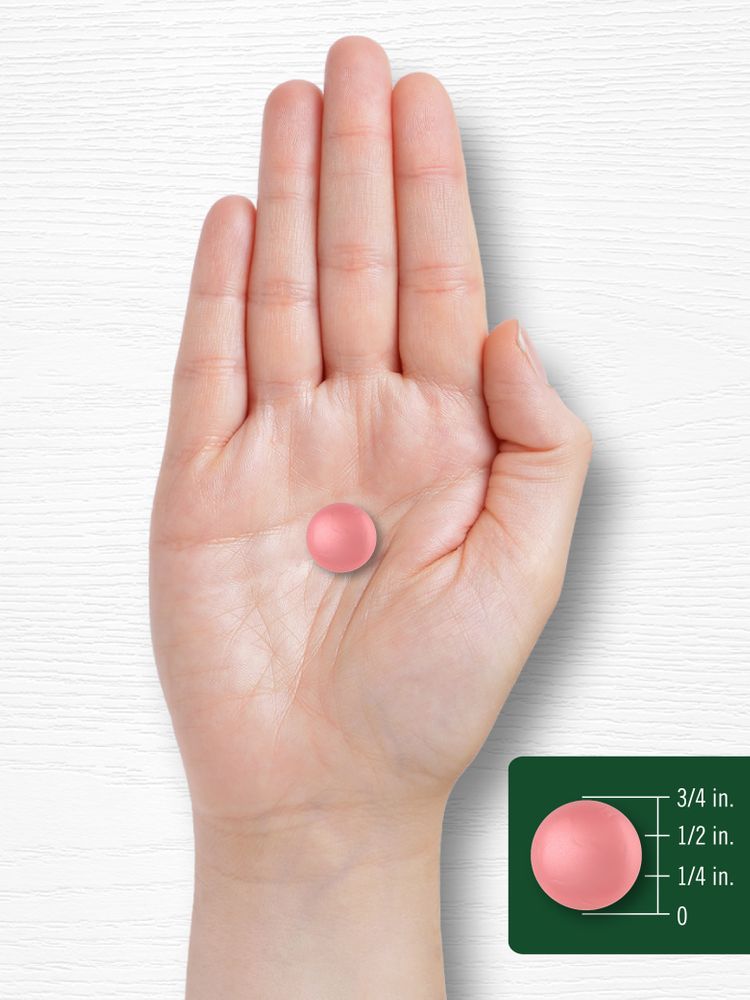 Pink, circular apple cider vinegar gummy, about 3/4 inch diameter, shown resting on a person's hand.