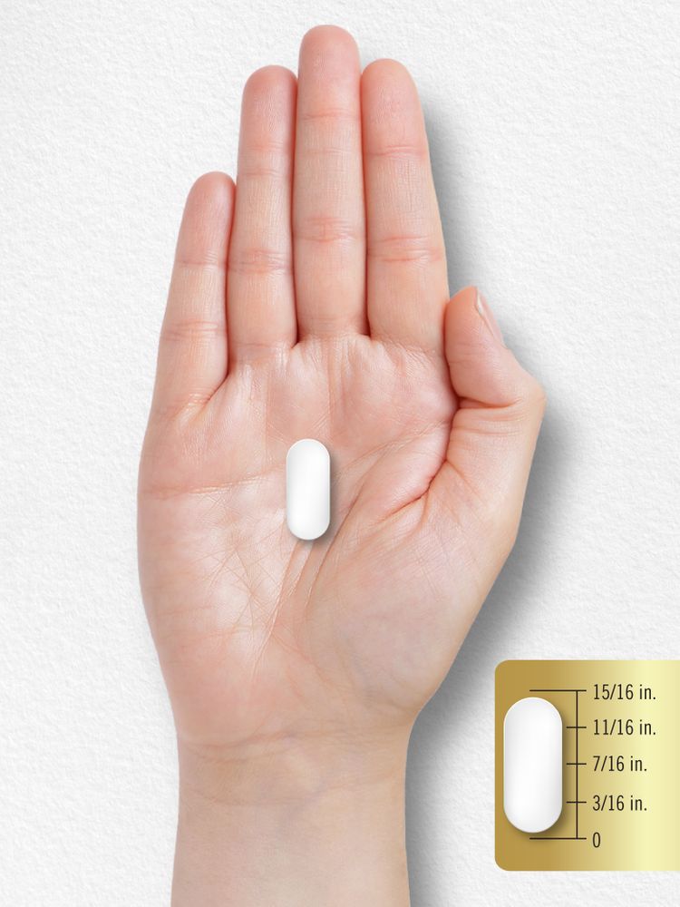 White caplet, 15/16 inch long, shown on a hand scale for measurement in bulk.