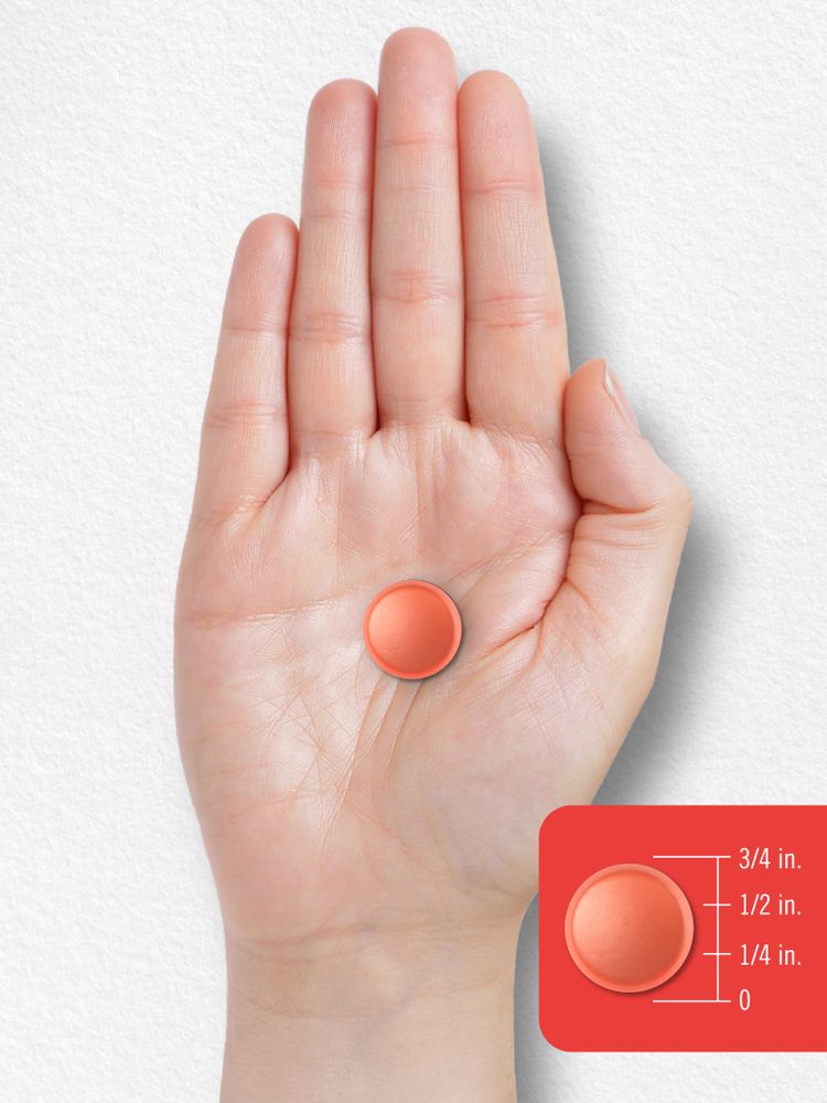 An orange gummy, half an inch in diameter, rests on a hand, highlighting its small size and vibrant color.