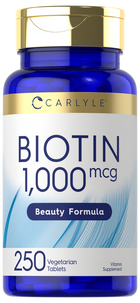 Carlyle Biotin 1,000 mcg bottle with 250 vegetarian tablets sits on a hand scale, indicating product weight and size.