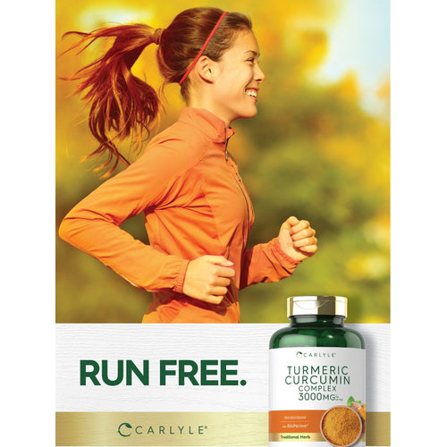 View 6 Young adult female jogging outdoors and smiling, holding a bottle of Carlyle Turmeric Curcumin Complex 3000mg.