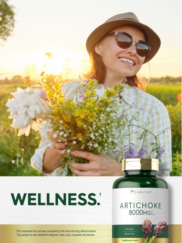 An adult woman smiling and holding wildflowers in a sunny field next to a bottle of Carlyle Artichoke 8000 mg.