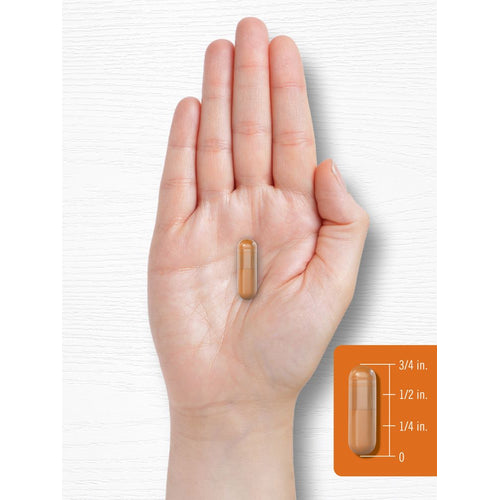 View 7 A capsule measuring three-fourths of an inch, used for demonstrating size against a hand scale.