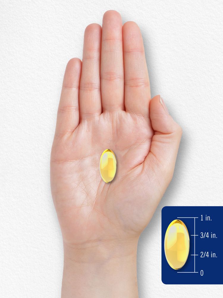 A hand holds a 1-inch long yellow oval softgel.